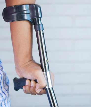 a person holding a crutch and walking cane